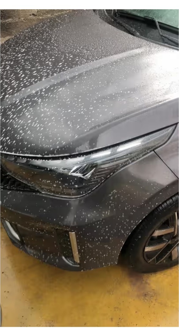Lavado artesanal de un auto gris con espuma